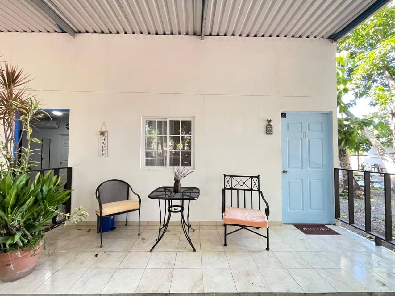 Patio cubierto con asientos y entrada de puerta azul